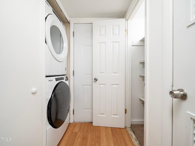 washroom featuring light hardwood / wood-style floors and stacked washing maching and dryer