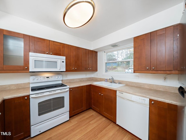 kitchen featuring sink, white appliances, and light hardwood / wood-style flooring