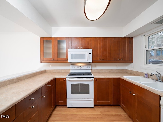 kitchen featuring sink, white appliances, and light wood-type flooring