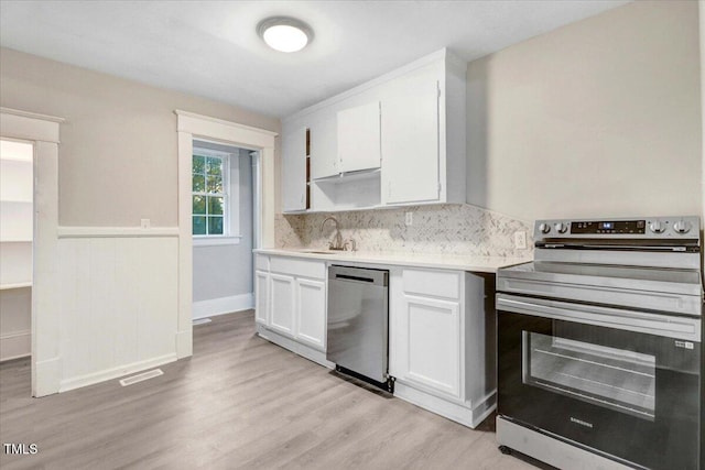 kitchen with sink, light hardwood / wood-style flooring, tasteful backsplash, white cabinetry, and stainless steel appliances