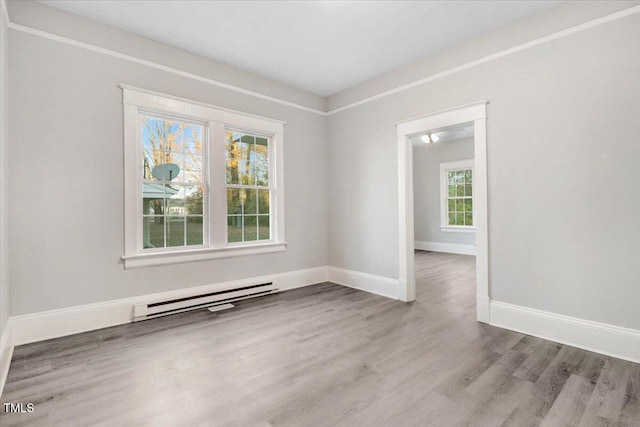 empty room with light hardwood / wood-style flooring and a baseboard radiator