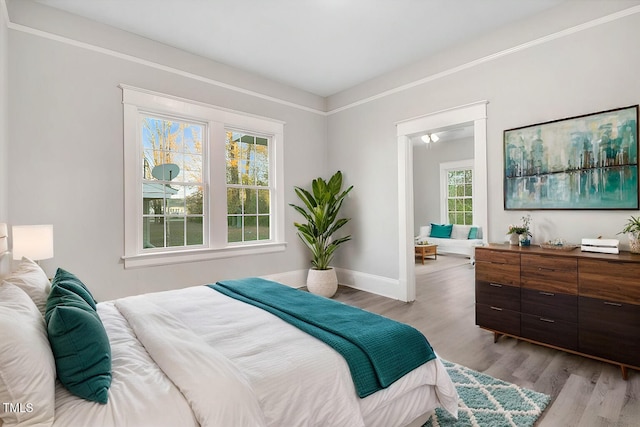 bedroom with light wood-type flooring and multiple windows