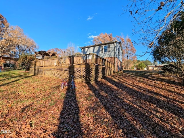 view of side of property with a wooden deck and a yard