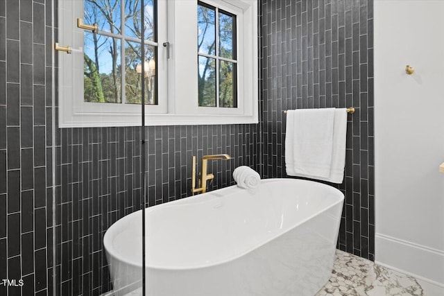 bathroom featuring a tub and tile walls