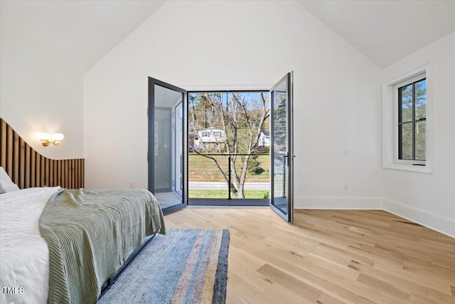 bedroom with lofted ceiling and light wood-type flooring