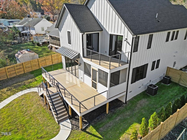 rear view of house with cooling unit, a wooden deck, and a sunroom