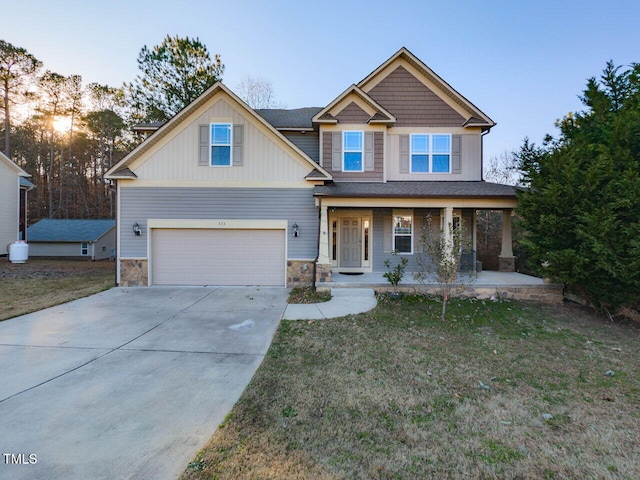 craftsman-style house featuring a yard, a porch, and a garage