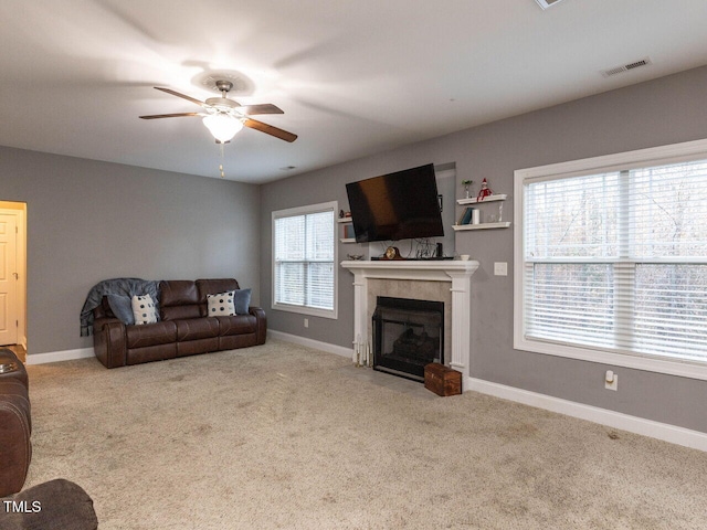 living room featuring light carpet, plenty of natural light, and ceiling fan