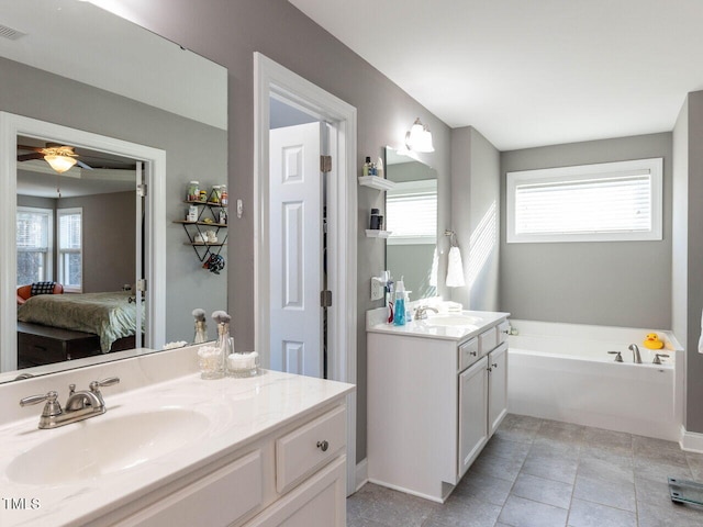 bathroom with a bathtub, vanity, a healthy amount of sunlight, and ceiling fan