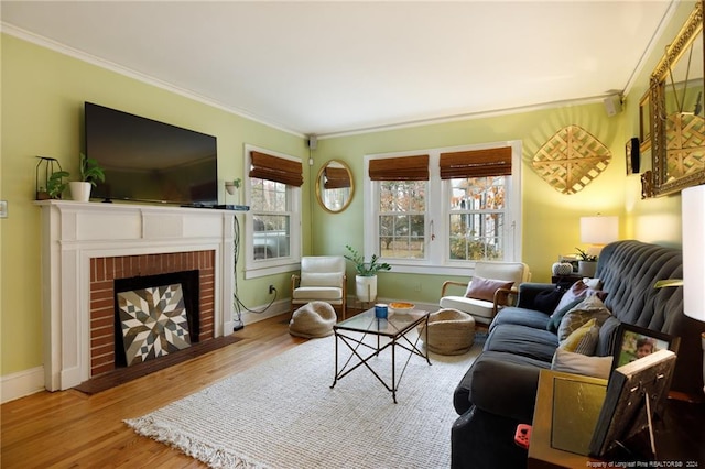 living room featuring hardwood / wood-style floors, crown molding, and a brick fireplace