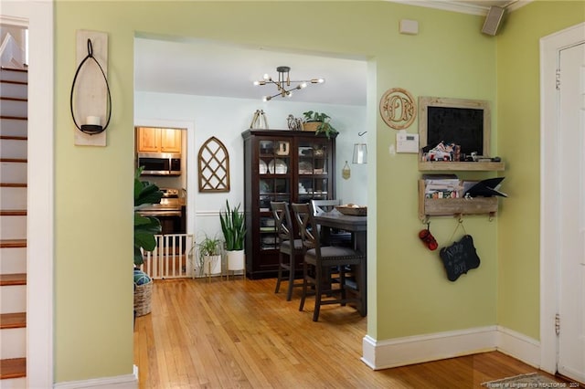 interior space featuring light hardwood / wood-style floors, crown molding, and a chandelier