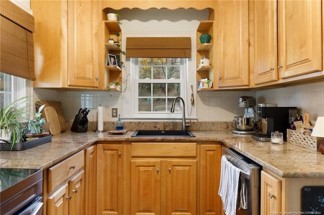 kitchen featuring light stone countertops, backsplash, and sink