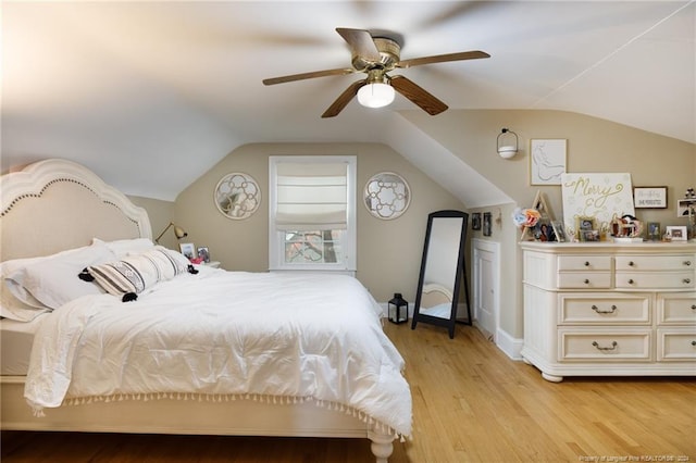 bedroom with ceiling fan, light wood-type flooring, and lofted ceiling