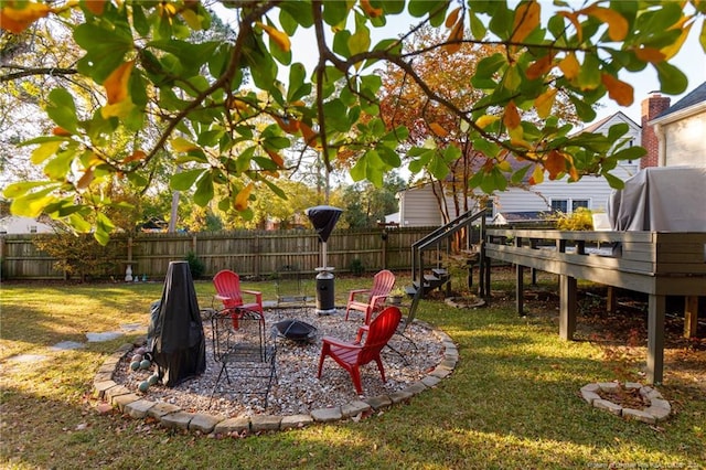 view of yard with a deck and an outdoor fire pit