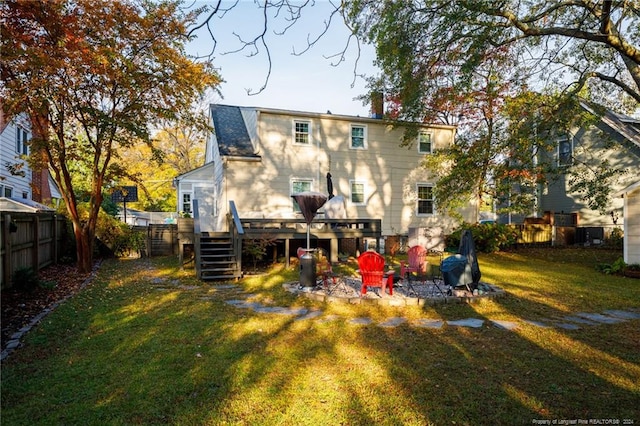 rear view of house with a lawn and a deck