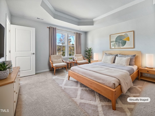 bedroom with light colored carpet, crown molding, and a tray ceiling