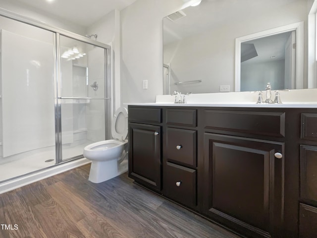 bathroom with wood-type flooring, vanity, toilet, and walk in shower