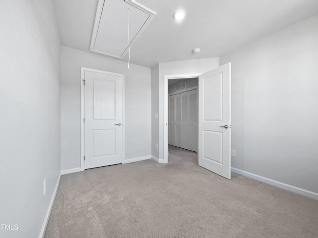 unfurnished bedroom featuring light colored carpet and a closet