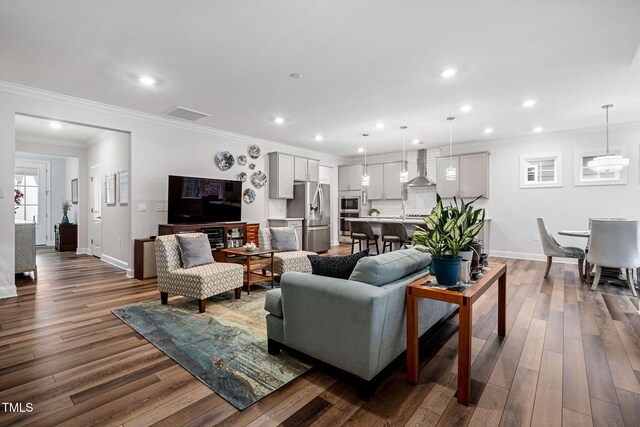 living room with dark hardwood / wood-style flooring and ornamental molding