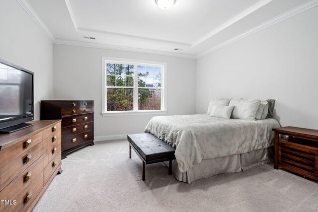 bedroom featuring a tray ceiling, light colored carpet, and ornamental molding