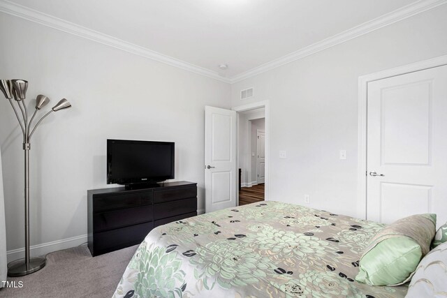 carpeted bedroom with ornamental molding