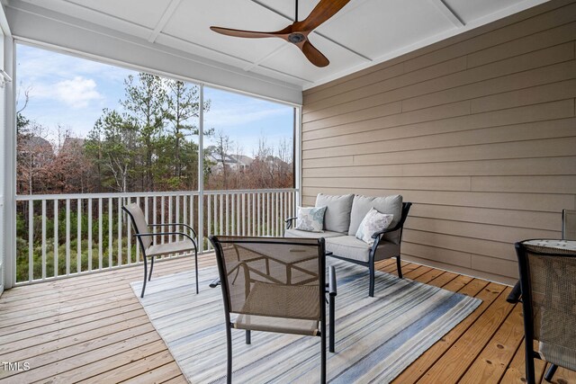 wooden deck with ceiling fan and an outdoor living space