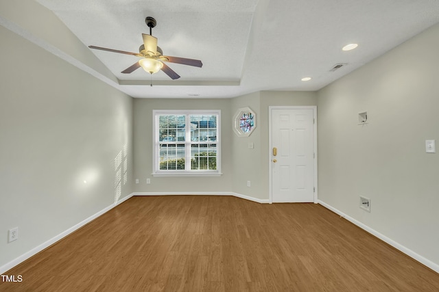 interior space with hardwood / wood-style flooring, ceiling fan, and a raised ceiling