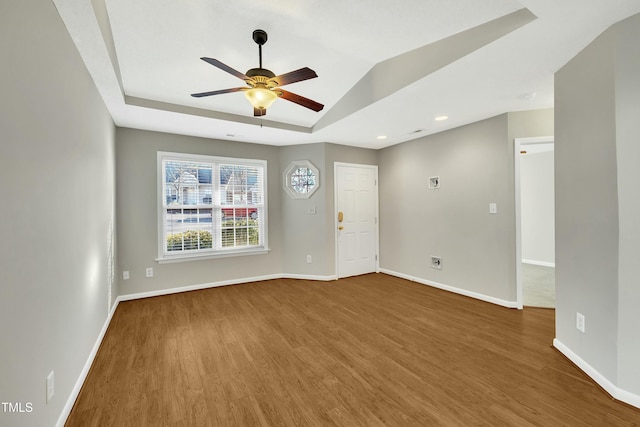 spare room featuring a raised ceiling, ceiling fan, and hardwood / wood-style floors