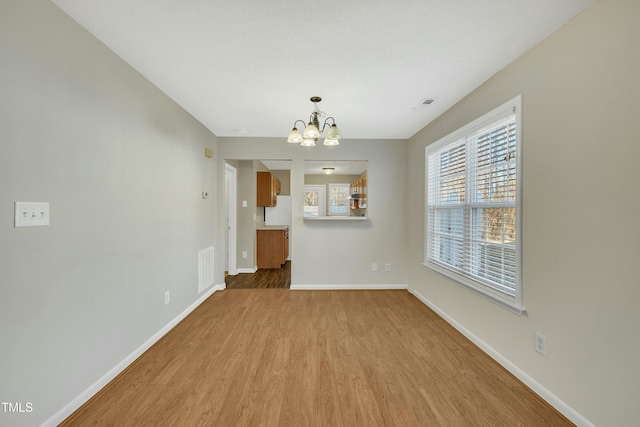 interior space with a chandelier and light hardwood / wood-style floors