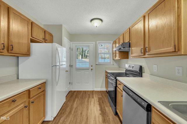 kitchen with sink, stainless steel appliances, a textured ceiling, and light hardwood / wood-style floors