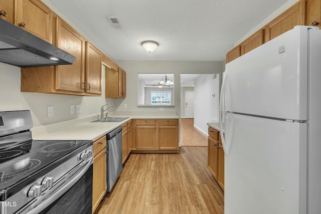 kitchen featuring sink, stainless steel appliances, a chandelier, a textured ceiling, and light wood-type flooring