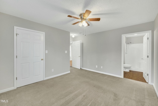 unfurnished bedroom with ensuite bath, ceiling fan, light colored carpet, and a textured ceiling