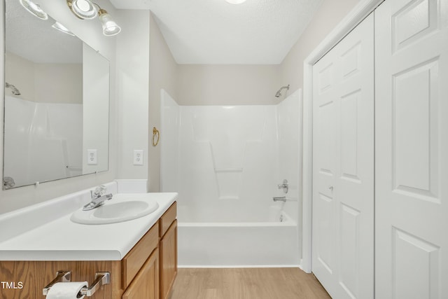 bathroom featuring shower / bathing tub combination, vanity, a textured ceiling, and hardwood / wood-style flooring