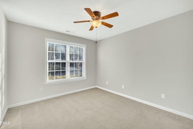 carpeted spare room with ceiling fan