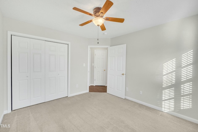 unfurnished bedroom with light carpet, a closet, and ceiling fan