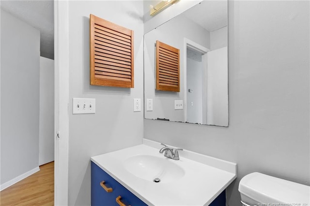 bathroom featuring vanity, hardwood / wood-style flooring, and toilet