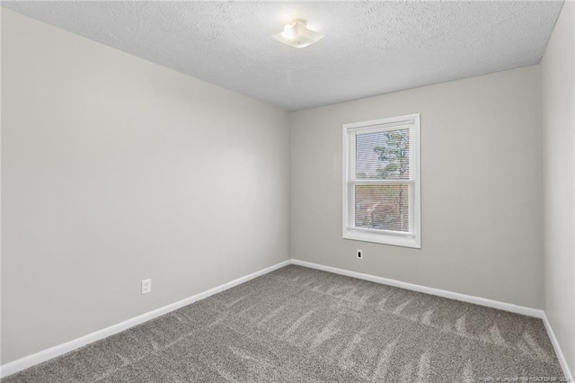 spare room featuring carpet flooring and a textured ceiling