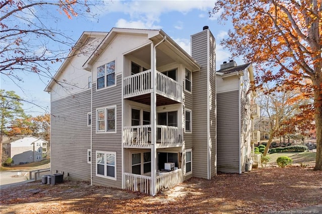 rear view of house with central AC and a balcony