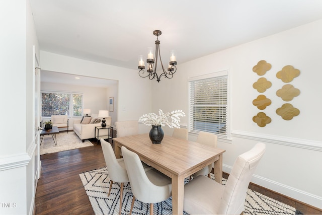 dining space featuring dark hardwood / wood-style floors and a notable chandelier