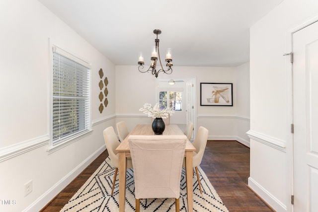 dining room with dark wood-type flooring and a notable chandelier