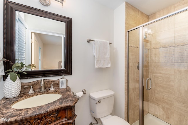 bathroom with vanity, toilet, and a shower with shower door