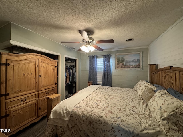 bedroom with ceiling fan, a spacious closet, a textured ceiling, and a closet