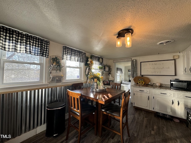 dining space featuring a textured ceiling and dark wood-type flooring