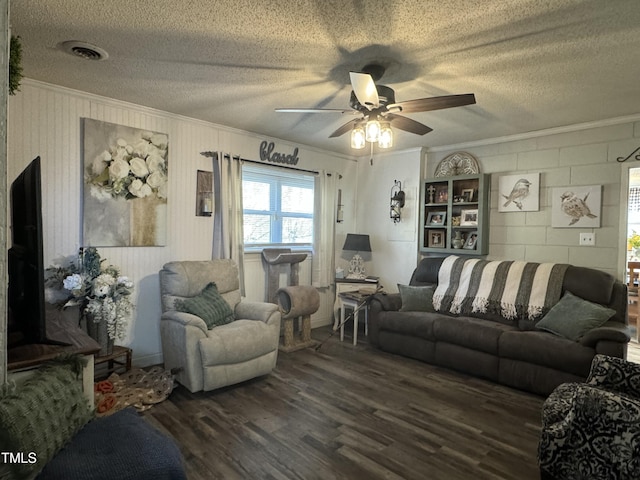 living room with a textured ceiling, dark hardwood / wood-style floors, ceiling fan, and ornamental molding