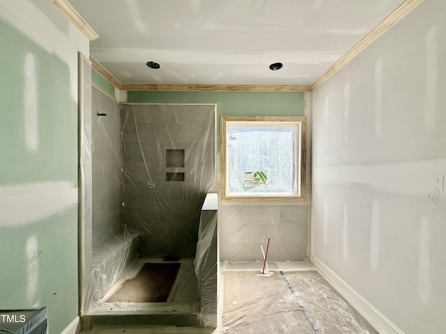 bathroom featuring crown molding and a marble finish shower