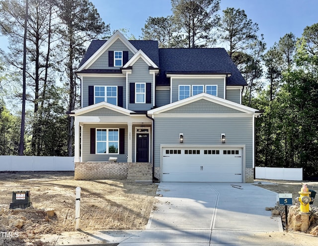 craftsman-style home featuring concrete driveway, a porch, an attached garage, and a shingled roof