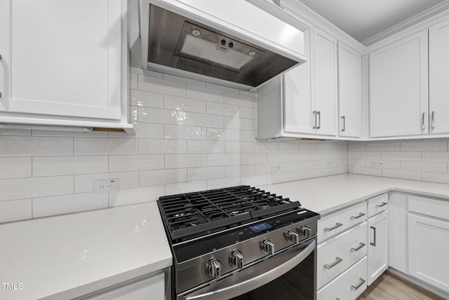 2625 Silver Gate Ct, Wake Forest, NC 27587 - kitchen featuring stainless steel range with gas cooktop, range hood, light countertops, white cabinets, and backsplash
