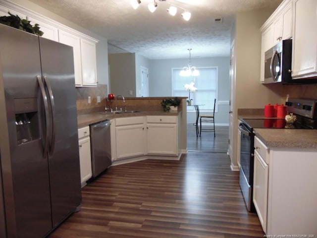 kitchen with pendant lighting, sink, white cabinetry, stainless steel appliances, and kitchen peninsula