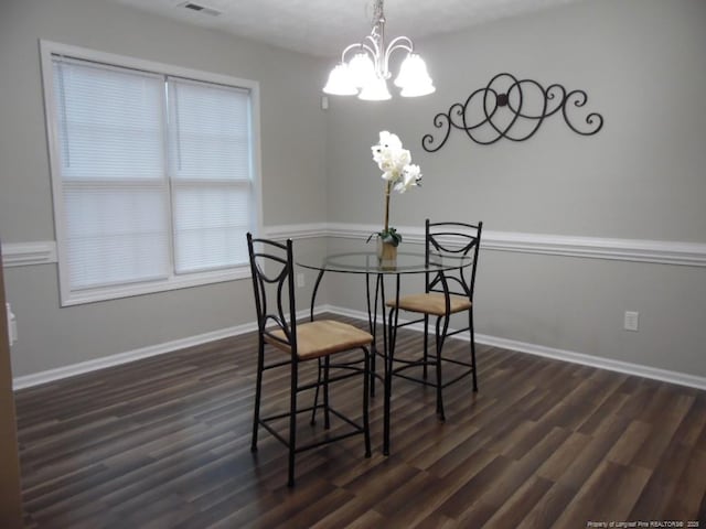 dining room featuring dark wood-type flooring and an inviting chandelier