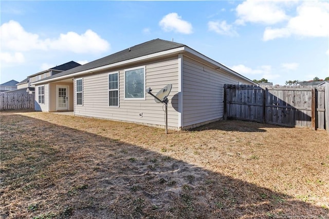 rear view of house featuring a lawn